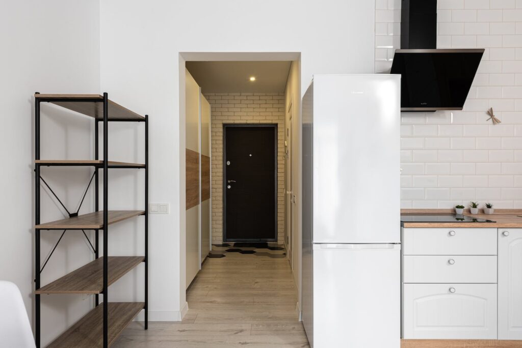 Entrance door against corridor and kitchen interior at home