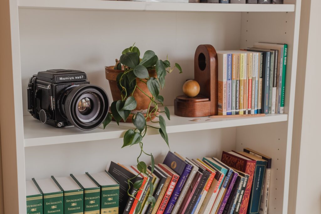 black and silver camera on white wooden shelf