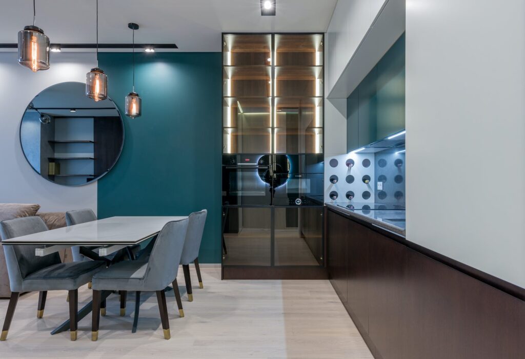 Creative interior of modern dining room with glass cupboard and mirror near table and comfortable chairs